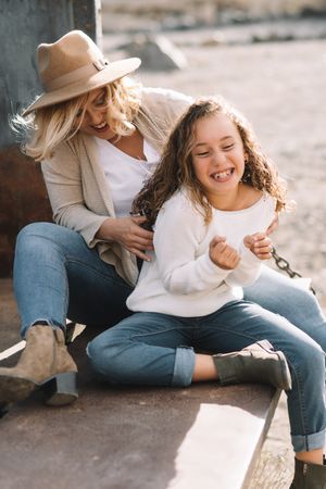 Mother hugging tickling girl in truck body
