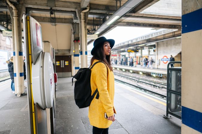Cheerful woman waiting to catch a train on station