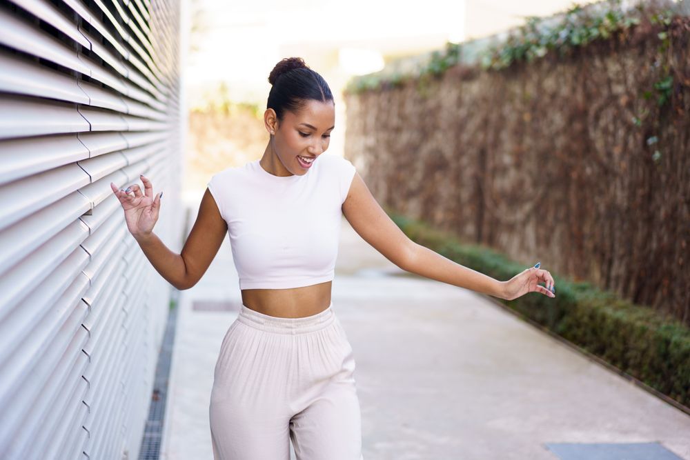 A Joyful, Young Woman Dancing Gracefully in a Vibrant Urban Setting Full of Life