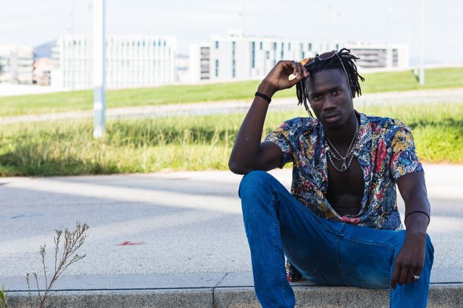 Stylish Black hipster man sitting on stairs in city