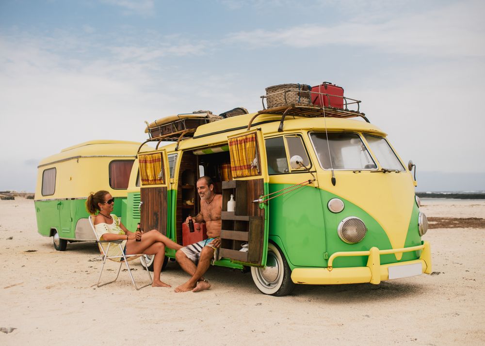 Friends in minibus with trailer on beach