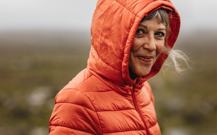 Close up of a smiling mature woman in a hooded jacket