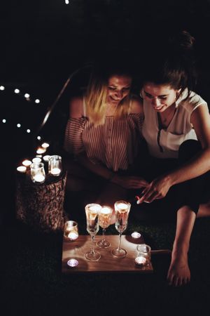 Couple with candles resting in night garden