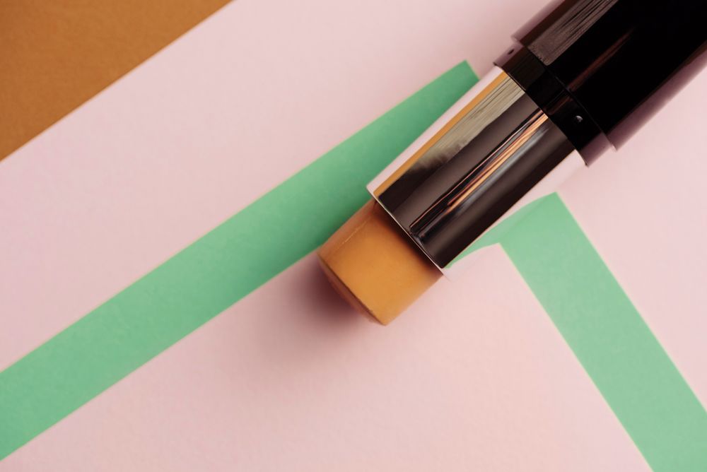 Concealer stick on modern background with geometric shapes.