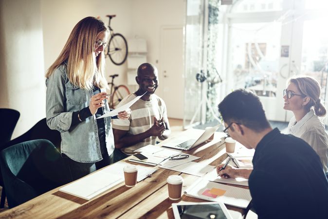 Woman addressing colleagues in open office