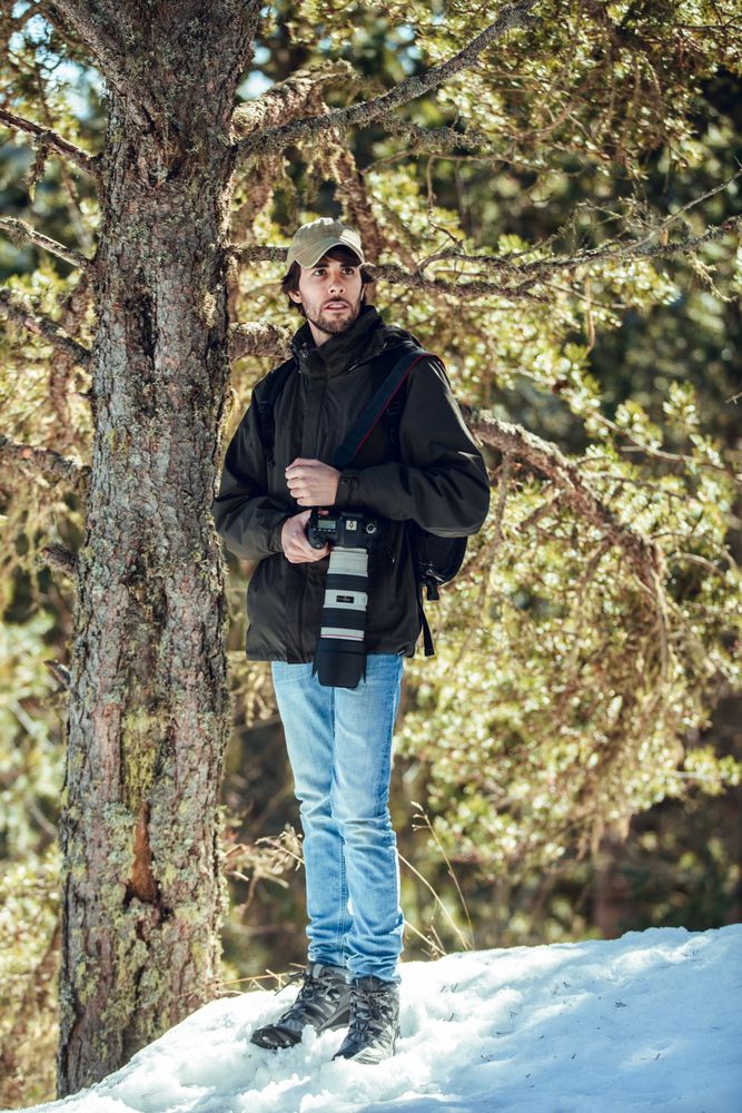 Man between winter forest in sunny day