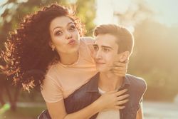 Teenagers are walking in the city park with girl making funny face