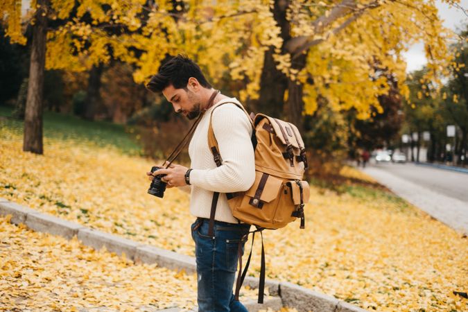 Trendy male with backpack and camera