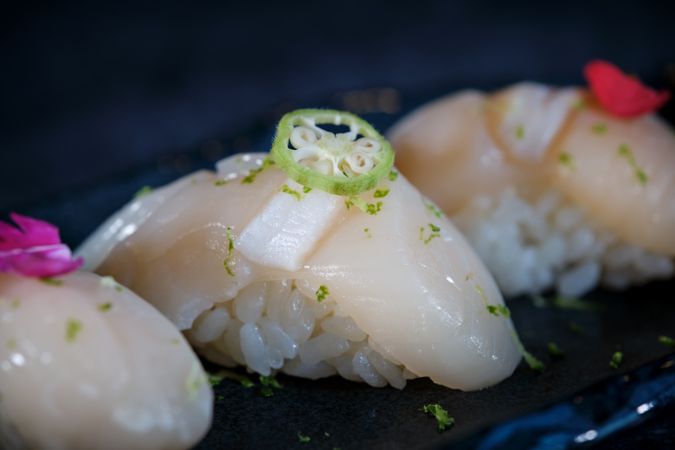 Delicious nigiri sushi with flowers on marble plate