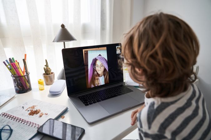 Anonymous boy making video call with classmate