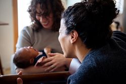 Female playing songs with guitar for baby and partner