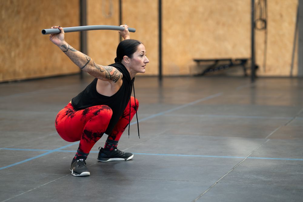Woman squatting with a bar in a gym