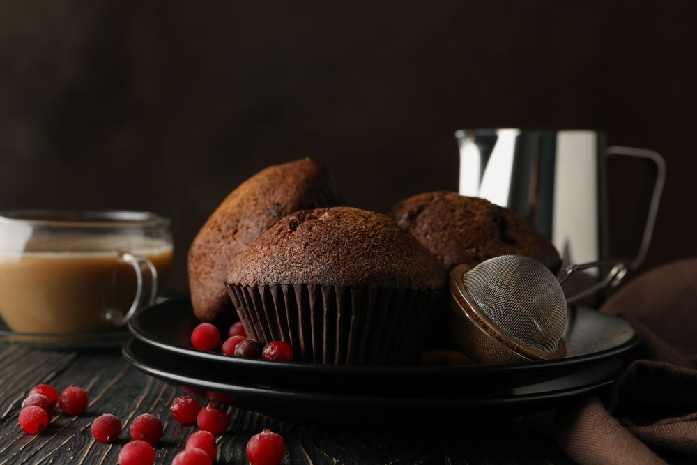Composition with tasty muffins and cocoa drink on wooden background