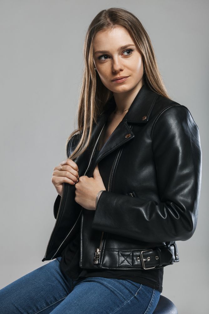 Blonde female with leather jacket posing in studio
