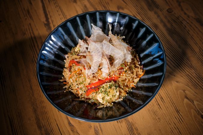 Delicious dish of rice in bowl served on wooden table