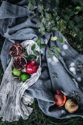Various fruits lying on fabric on grass