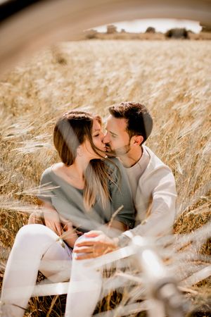 Loving couple resting on rye field