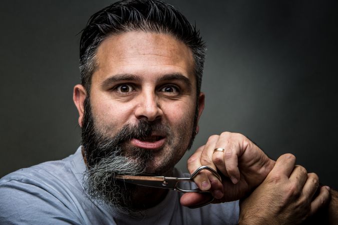 Expressive barber cutting beard