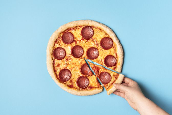 Pepperoni pizza and taking a slice of pizza