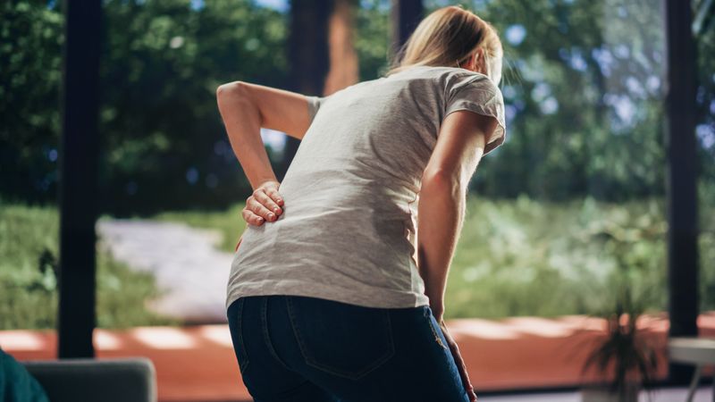 Close Up of a Female Experiencing Discomfort in a Result of Spine Trauma or Arthritis.