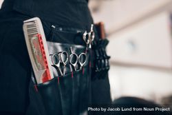 Closeup of scissors and combs in salon holster pouch 0gjmAb
