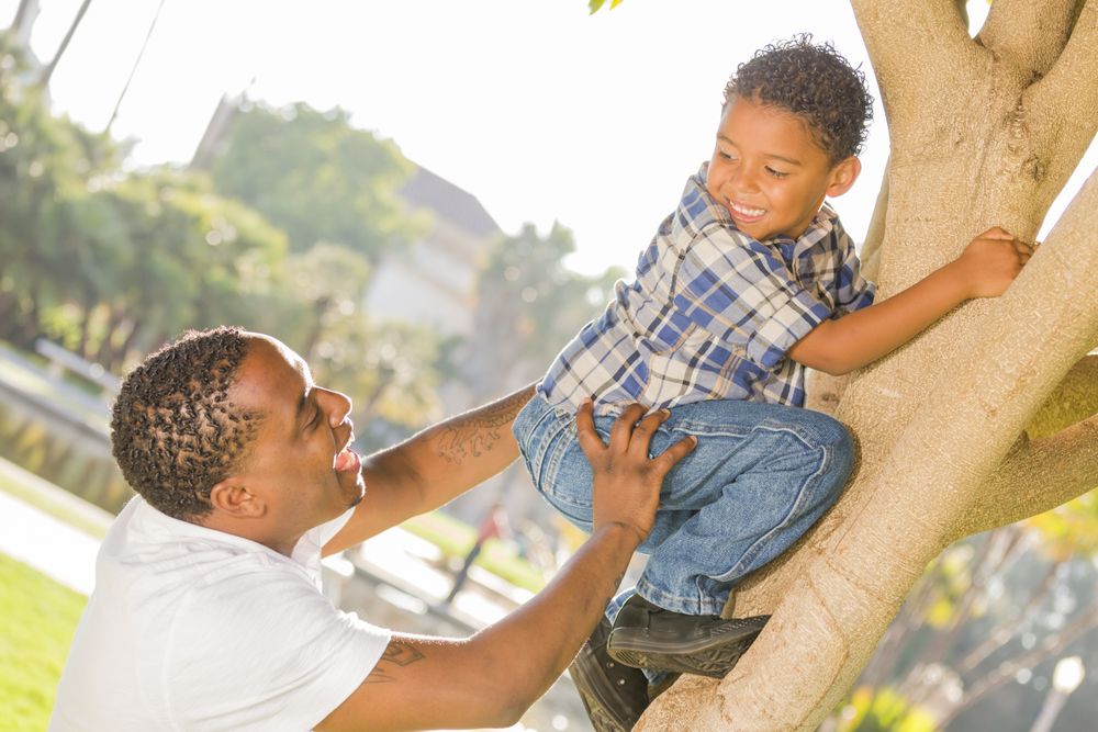 Happy Father Helping Son Climb a Tree