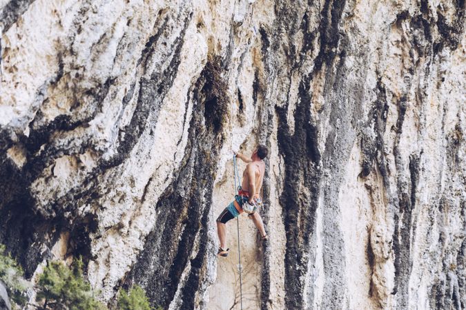 Anonymous man climbing rock