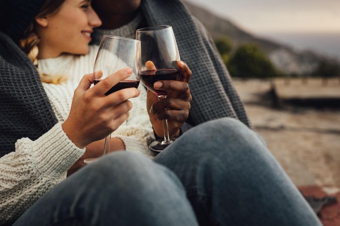 Romantic couple wrapped in a blanket and drinking wine