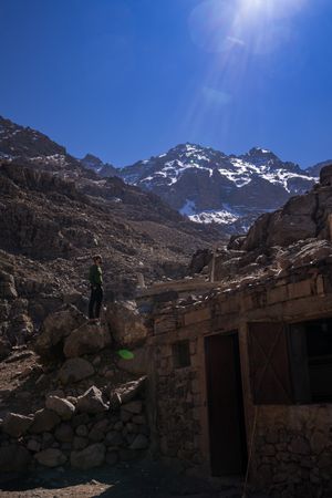 Distant man standing by rural building at mountain valley
