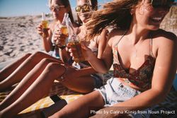 Group of young women drinking beer at the beach k4MNlb