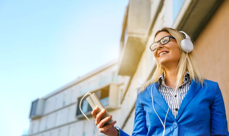 Businesswoman with headphones and mobile
