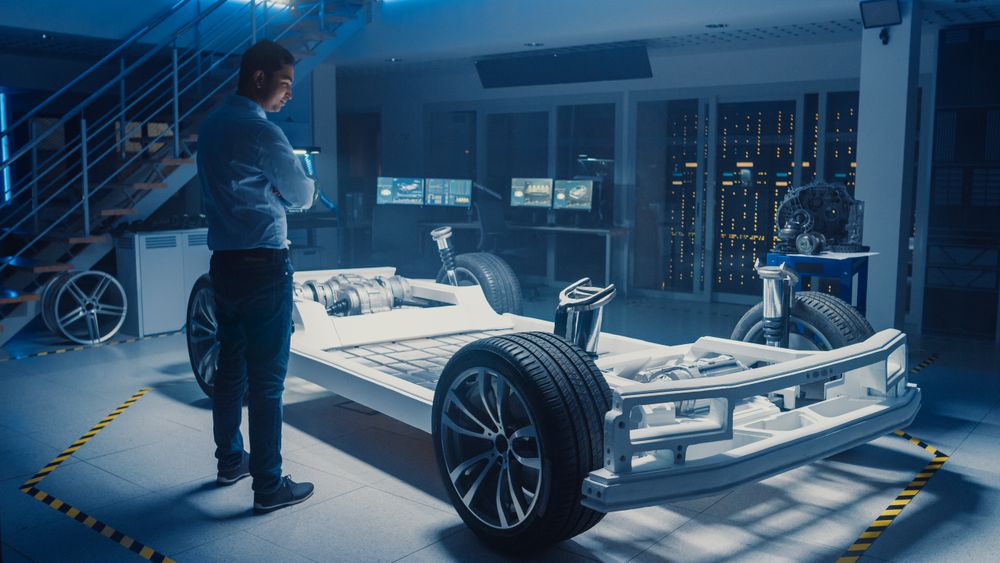 Automobile Design Engineer in Automotive Innovation Facility and Working on Electric Car Platform Chassis Prototype that Includes Wheels, Suspension, Hybrid Engine and Battery.