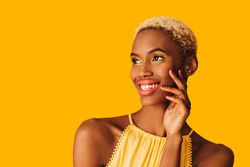 Black woman with short blonde hair with hand to cheek