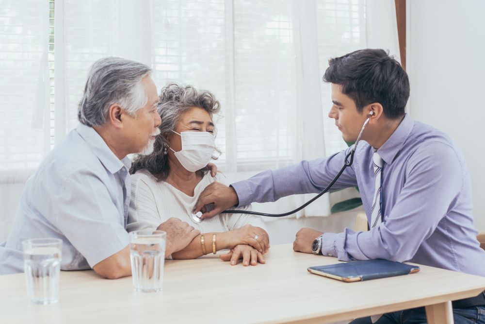 Doctor using stethoscope on mature older woman