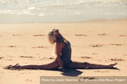 Athletic woman doing splits on a beach bYx614