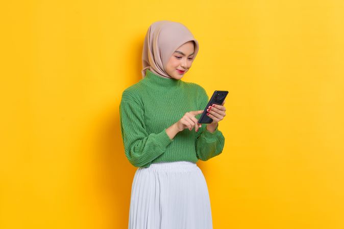 Woman in headscarf reading her smart phone
