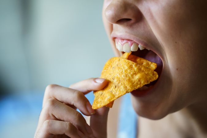 Girl biting into tortilla chips