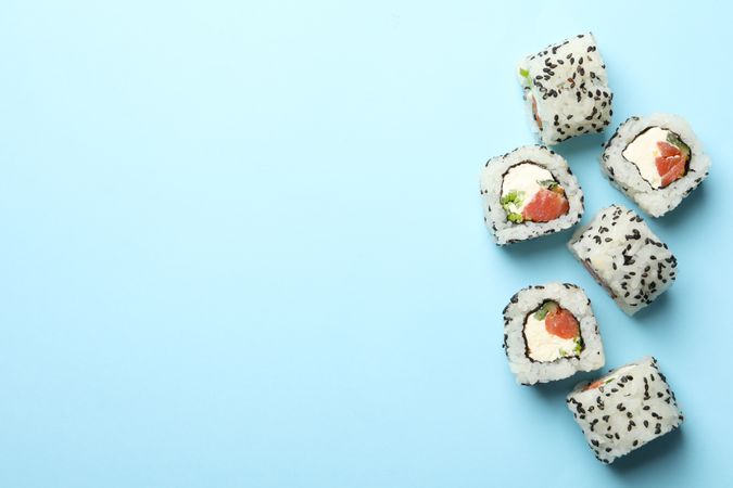 Delicious sushi rolls on blue background. Japanese food