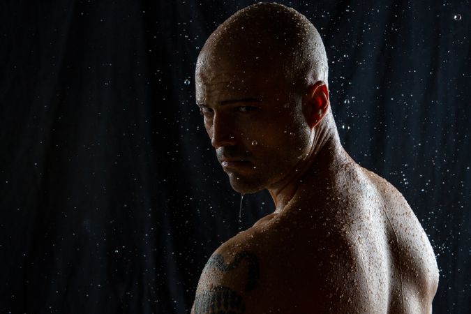 Serious bald man under rain