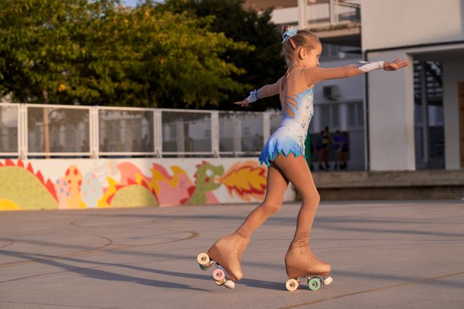 Active girl practicing roller skating on street