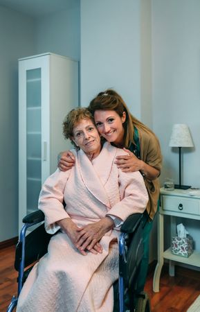 Affectionate caretaker posing with mature patient