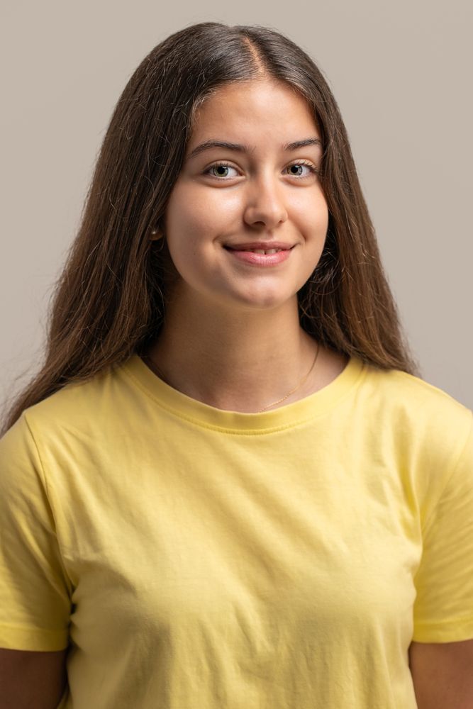 Simple and direct studio headshot of a smiling young woman.