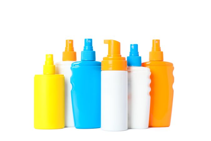 Many different sunscreen sprays isolated on light background. Summer vacation accessories