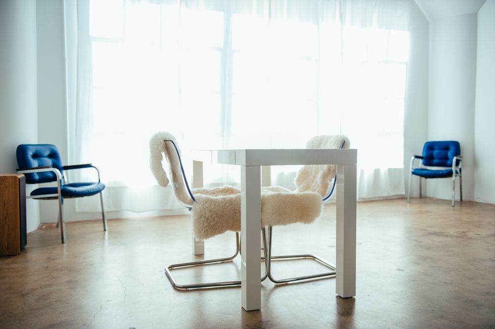 Bright office space with large windows, desk and chairs