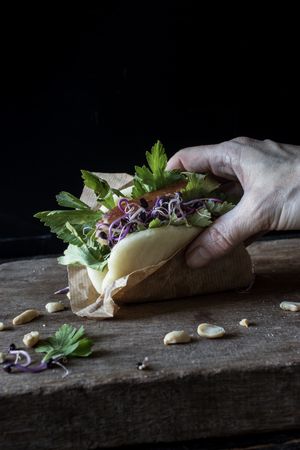 Crop person having traditional Gua Bao sandwich