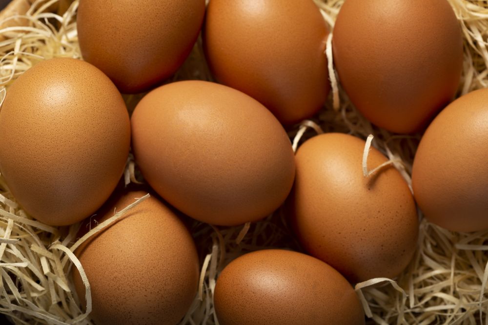 Basket with brown chicken eggs goes up the table.