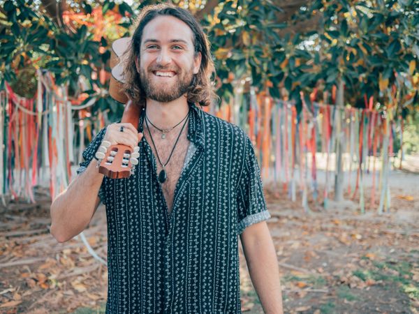 Hipster man in jungle with ukulele