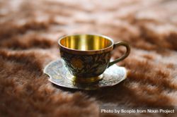 Golden cup and saucer on textile 5kwgW5