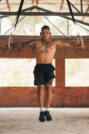 male athlete doing iron cross in gymnastic rings