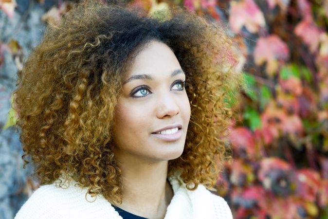 Portrait of woman looking up with fall leaves in background
